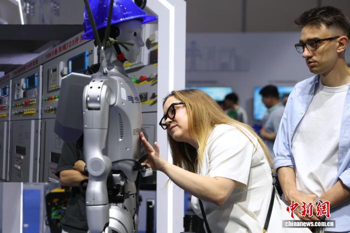 中新社记者在WRC 2026现场拍摄的知行者1号电力人形机器人,观众正在触摸体验