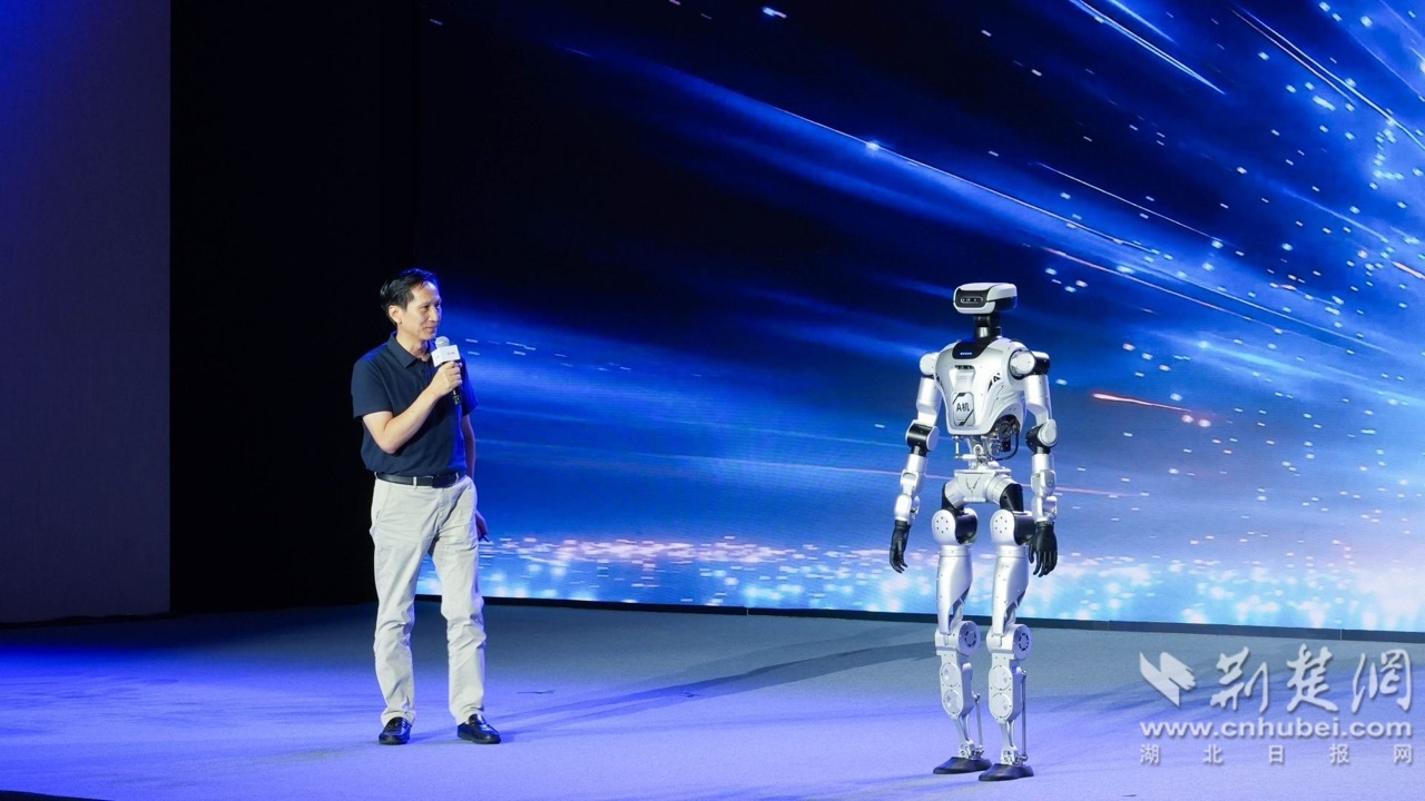 发布会现场人形机器人演示,演讲者介绍国产电子架构