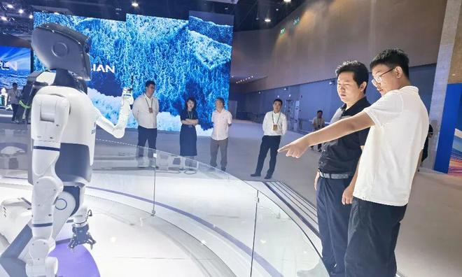 观众在展台前观看轮式人形机器人演示