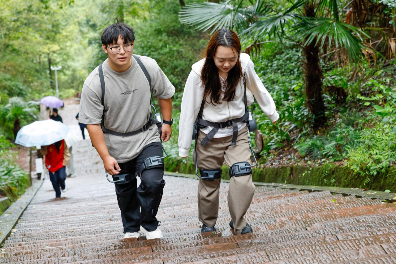 游客穿戴外骨骼机器人在景区台阶上行
